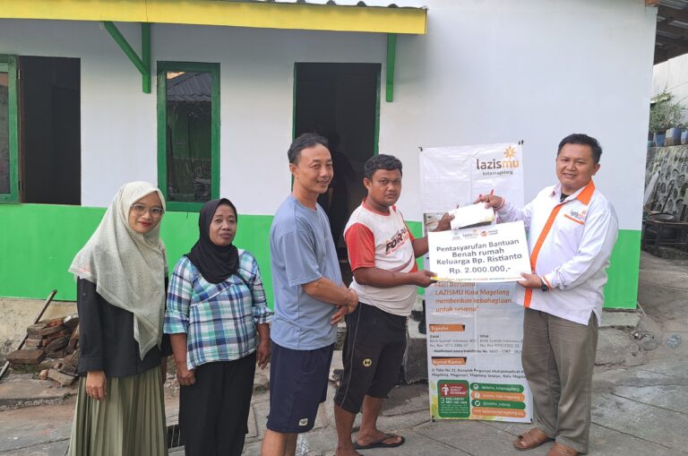 MENYERAHKAN. Sigit Priyanto (kanan) selaku Badan Pengurus Lazismu Kota Magelang menyerahkan secara simbolis program benah rumah kepada keluarga bapak Ristanto